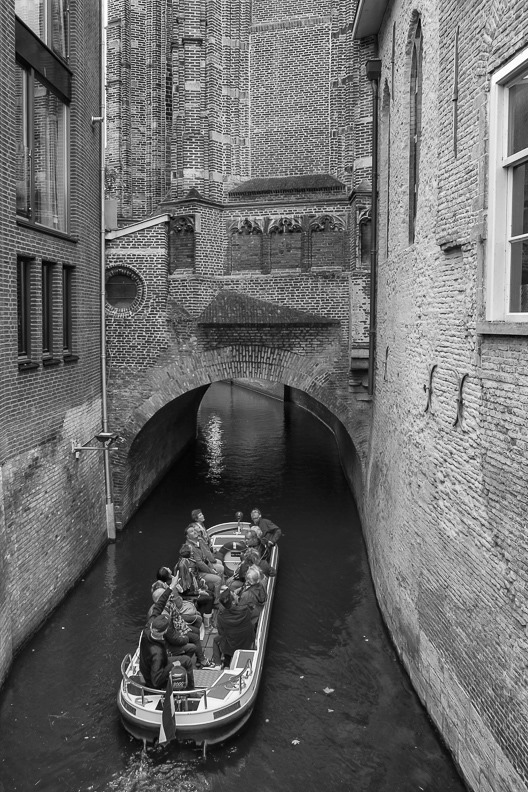 de binnendieze onder de kruiskerk of sint-cathrien in den bosch. met een rondvaartbootje dat over de kerkstroom vaart.